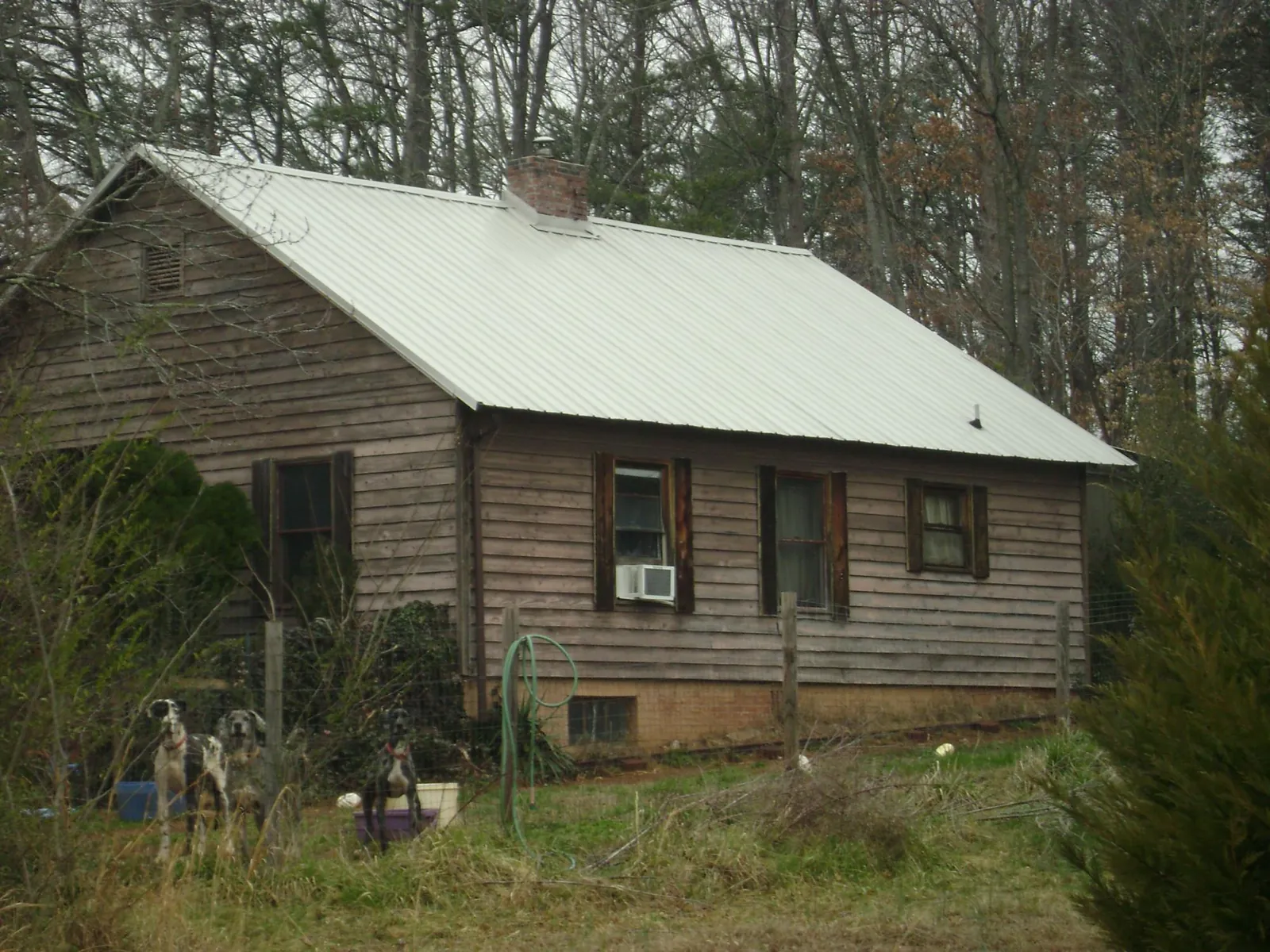 White metal roof on an old wood sided farmhouse, from a Metal Roof Installation job in Alamo